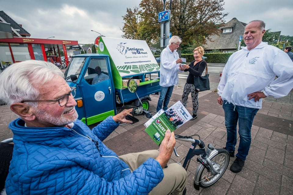 Senioren Dijk & Waard voert campagne met een Piaggio. Op de achtergrond informeert Jan van der Starre een potentiële kiezer.