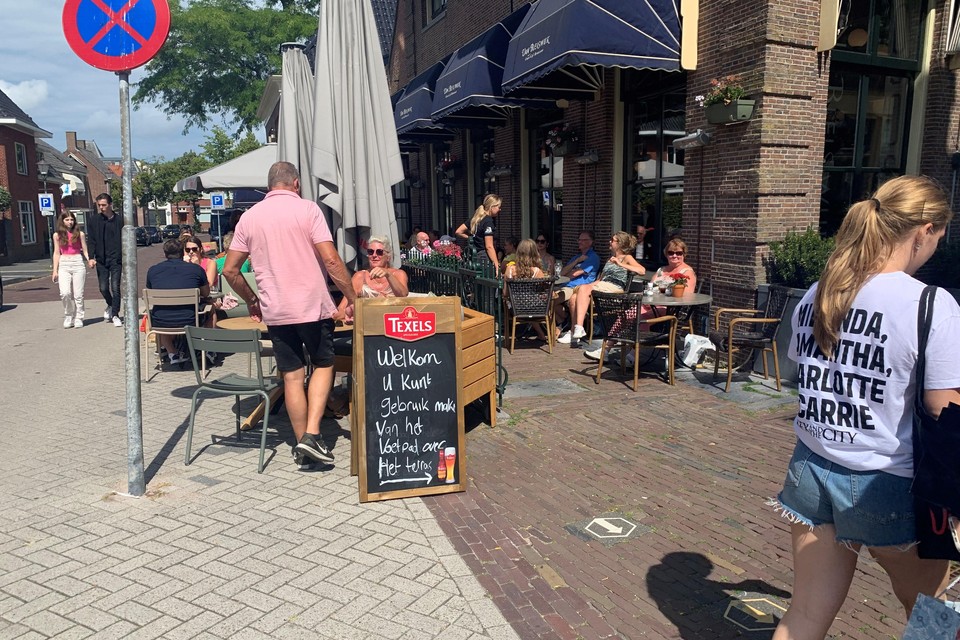 Het terras van restaurant Van Bleiswijk, met in het midden een looppad. Langs het terras lopen mensen op straat.