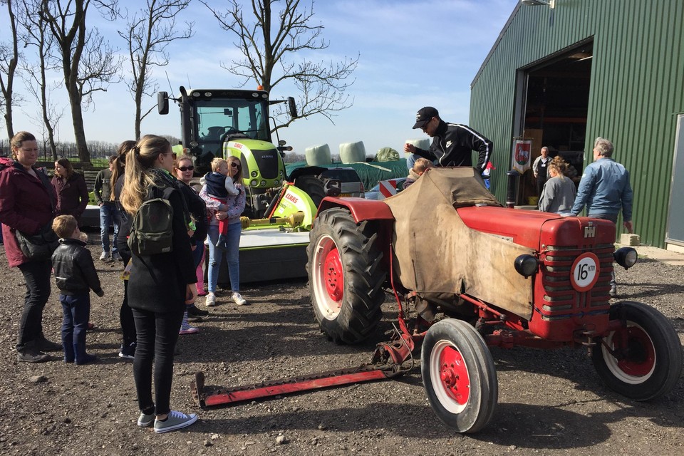 Kinderen worden op tractor gehesen, alsof zij de nieuwe jonge boeren zijn.