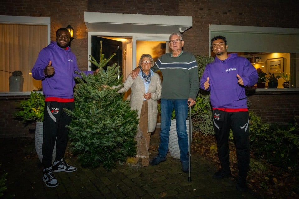 De AZ-spelers Bruno Martins Indi en Owen Wijndal leveren een kerstboom af bij AZ-fan Fons Jansen.