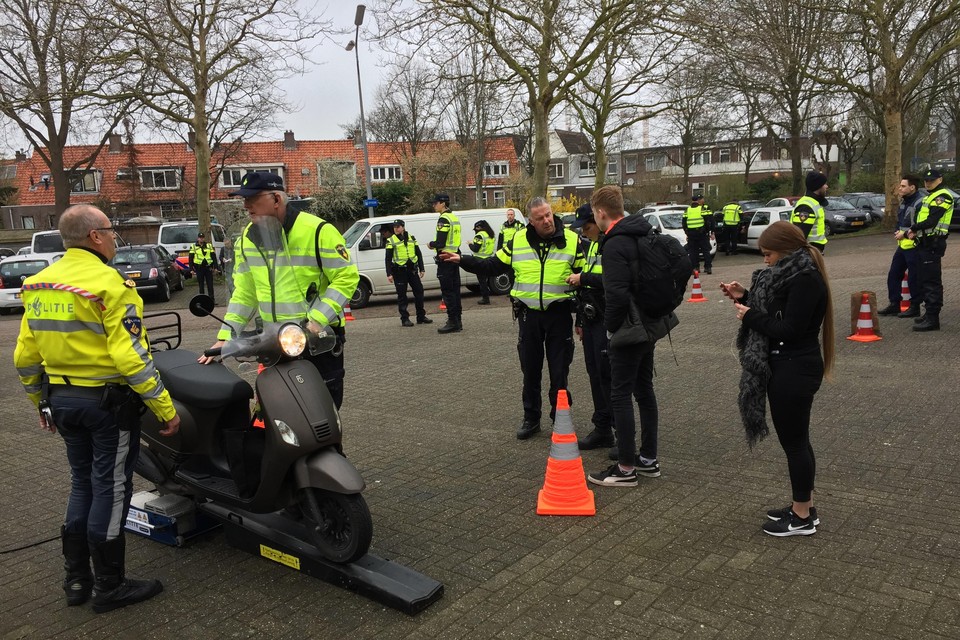 Jongeren met bromfietsen en scooters worden gecontroleerd door de politie.