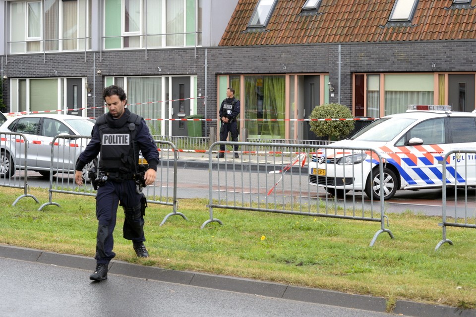 Een speciaal politieteam bewaakt de woning waarin de overleden man en de drugs zijn aangetroffen. Foto Ella Tilgenkamp