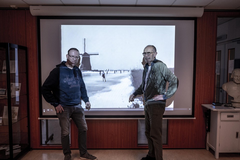 Vincent Hoogendijk en Cees de Groot voor een scherm met beelden uit de schaatsfilm.