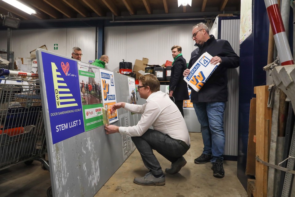 De VVD-fractie Opmeer plakt haar eigen posters op de borden.