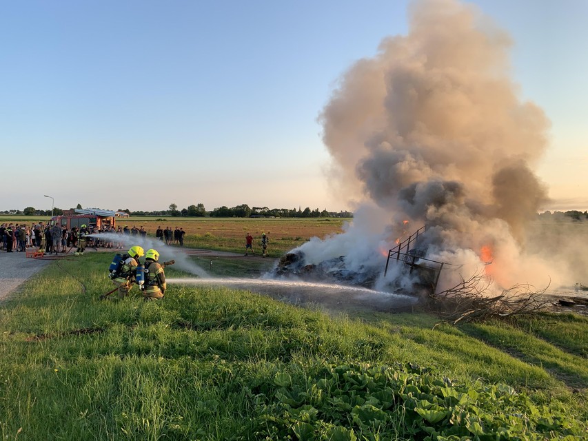 Boeren hadden naast een weiland een veekar en hooibalen in brand gestoken.