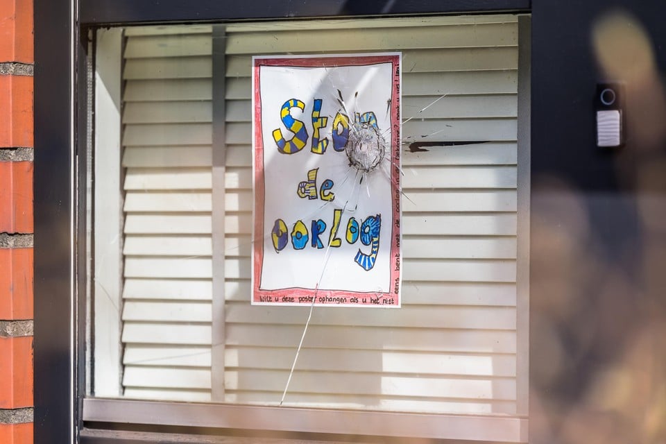 Het raam met een protestposter ’Stop de oorlog’ werd met een kogel doorboord.