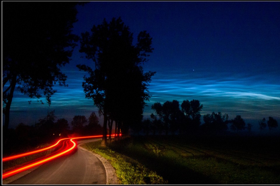 Lichtende nachtwolken met daaronder de achterlichten van de auto van Theo Hoogerhuis.
