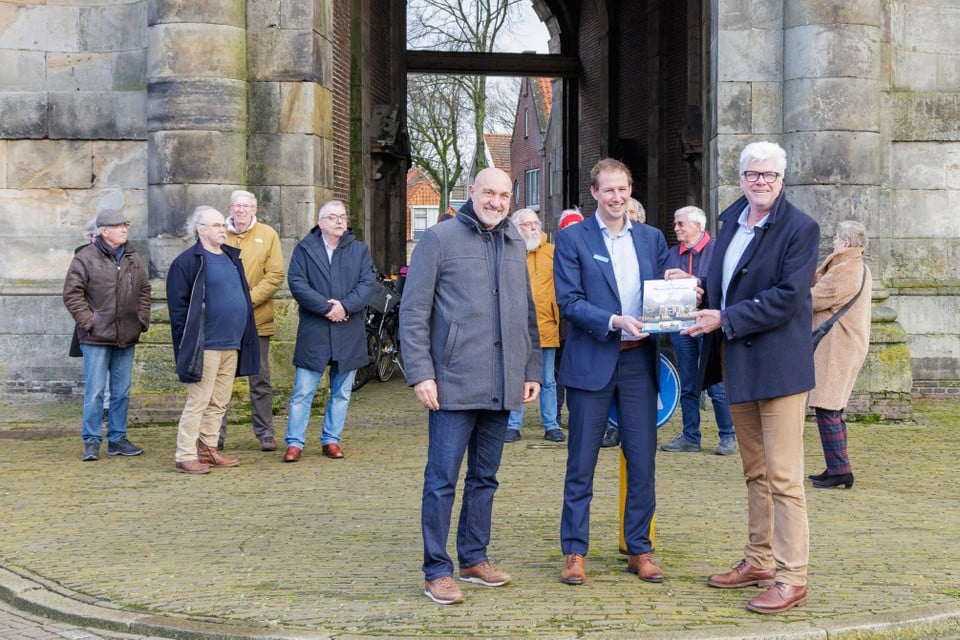Cees Groot van Oud Enkhuizen met supermarktmanager Roy Zinger en wethouder Dorus Luyckx, die het eerste exemplaar van Historisch Enkhuizen krijgt.