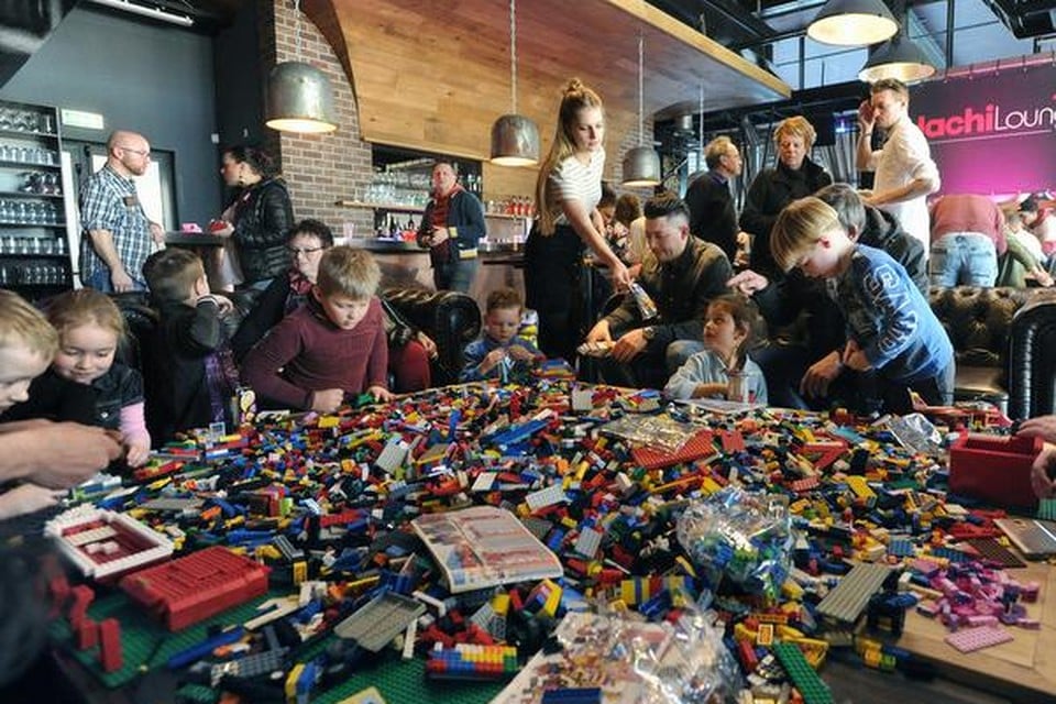 
Zo’n 35 kinderen storten zich, vaak geholpen door ouders, op de duizenden stukjes Lego.
