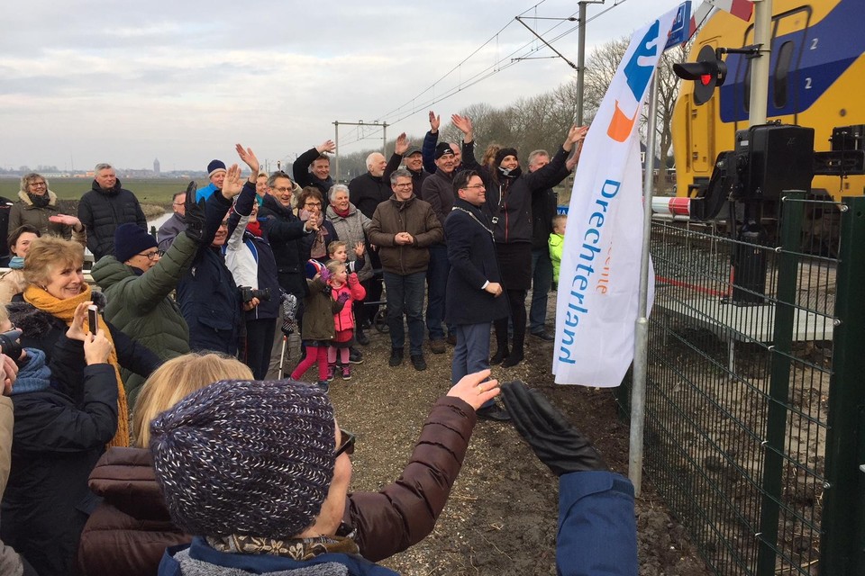 De Westwouders en hun burgemeester zwaaien naar een passerende trein bij het nieuwe Cor Schipperpad langs de Binnenwijzend