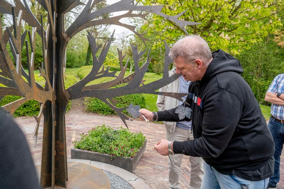 Raymond Groen monteert een naamblaadje ter ere van zijn overleden schoonvader aan de Gedenkboom, bij de ingebruikname vorig jaar mei.