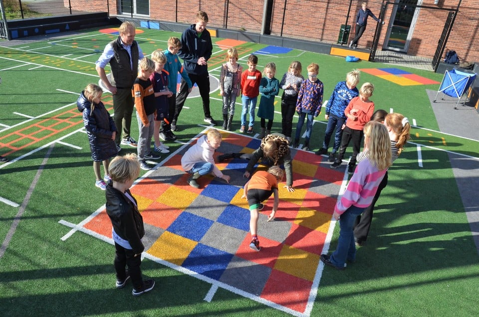 Sportwethouder Bart Krijnen van Koggenland ziet hoe leerlingen gebruik maken van het multifunctionele sportveldje bij De Droomgaard.