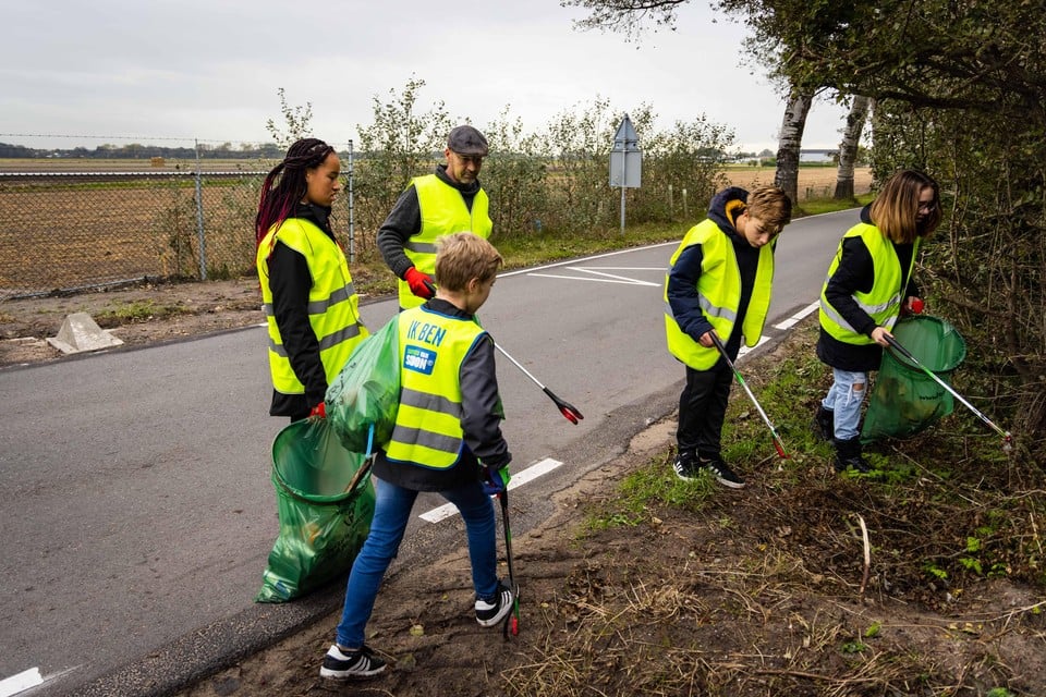 Gewapend met tangen en vuilniszakken ruimt een groep vrijwilligers het ergste zwerfvuil op.