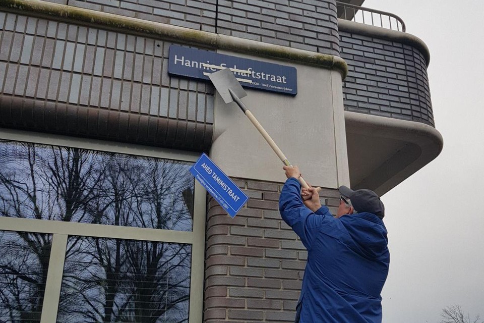 Herman Wijkhuisen wipt met een schep het omstreden bordje weg waardoor de naam van Hannie Schaft weer zichtbaar wordt.