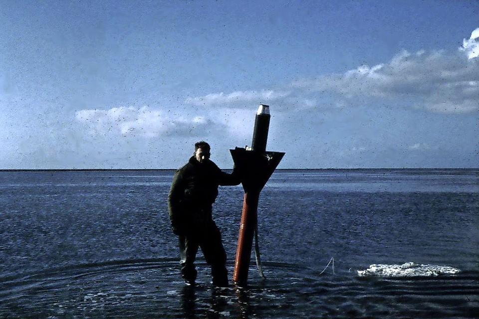 Een model na terugkeer van een proefvlucht in de bijna drooggevallen Waddenzee. Rechtsonder de parachute waaraan het model zacht neerdaalde.