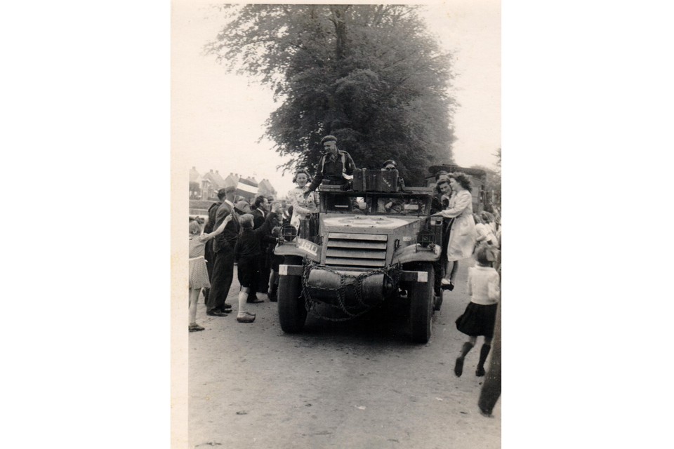 Feestelijke intocht van Canadese militairen in ’t Zand, 8 mei 1945. Rechts op de treeplank van de legerwagen Marie Glas (in het wit) en Alie Boots.
