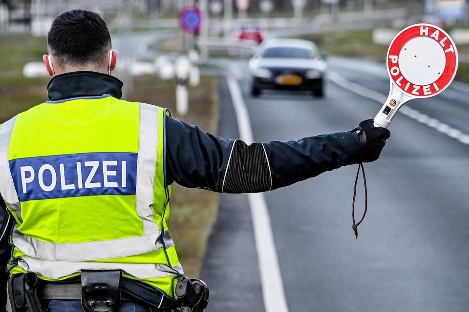 Een Duitse agent gebiedt een Nederlandse automobilist te stoppen voor een controle.