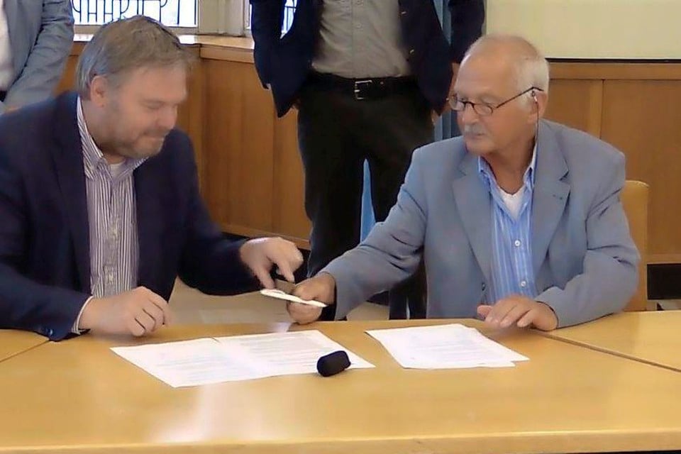 Frans Endel van de Sportraad (rechts) geeft de pen voor de ondertekening aan wethouder Rob Opdam.