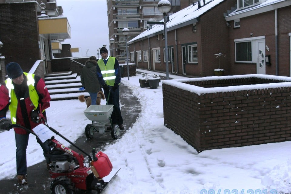 De vrijwilligers zijn druk bezig met het sneeuwruimen.