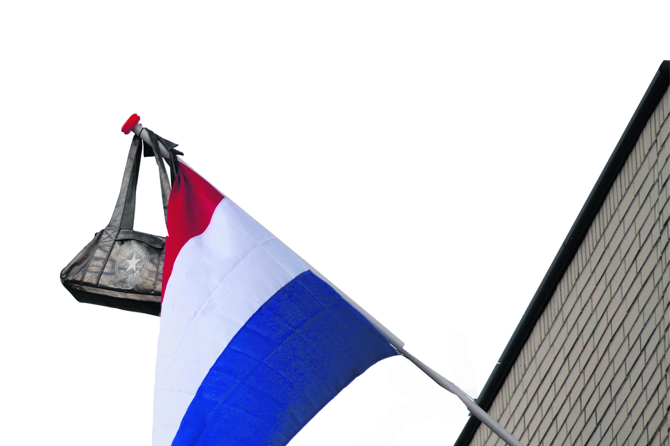 2016-06-16 19:06:17 HOEK VAN HOLLAND - Een vlag met een tas aan de gevel van een woning in Hoek van Holland. Voor honderdduizenden middelbare scholieren was het een spannende dag - geslaagd voor het eindexamen of niet. ANP JERRY LAMPEN
