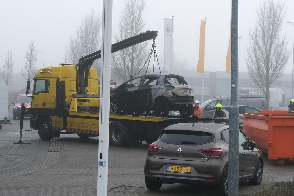 Het wrak van de uitgebrande Renault wordt opgeladen dinsdagmorgen.