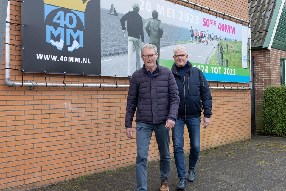 Bestuurders Piet Boon (links) en Vok Manshanden bij de banner voor de 50e 40MM. ,,Wij faciliteren de tocht, maar het dorp doet het.’’