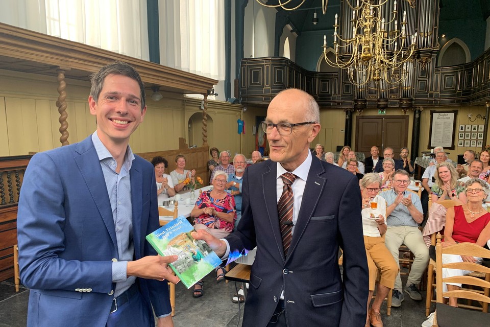 Lourens Schuitenmaker (l) krijgt het eerste jaarboek genootschapsvoorzitter Jan Smit.