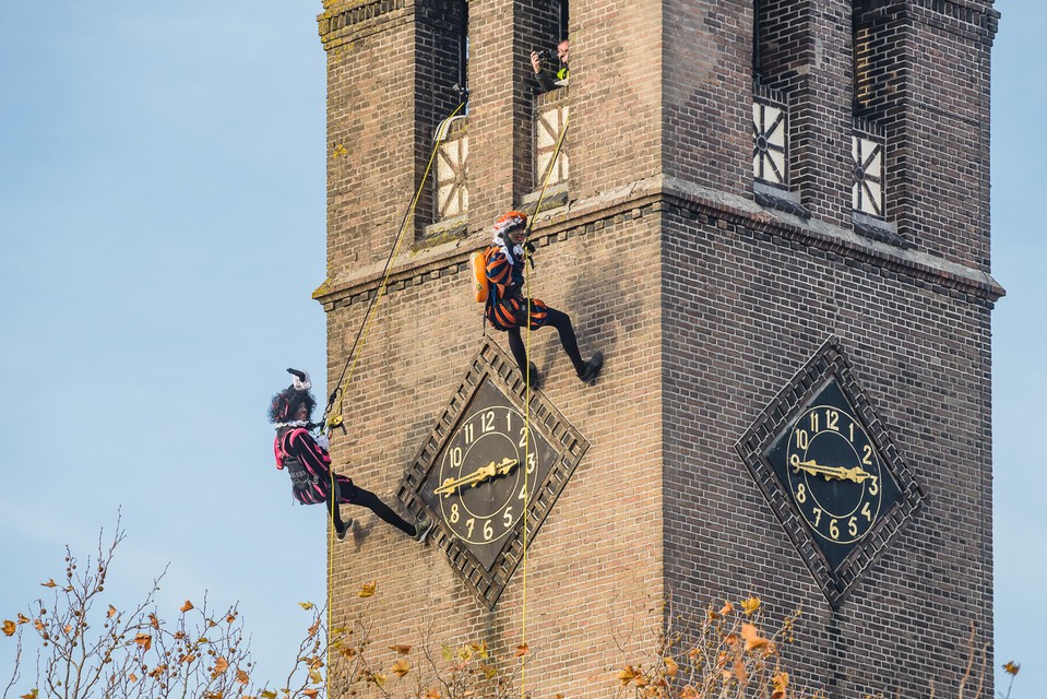 Zwarte Pieten klimmen van de toren.