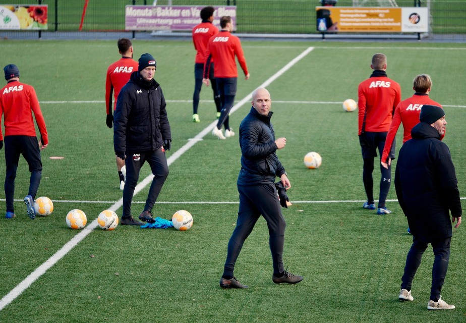 De huidige hoofdtrainer, John van den Brom (links), en de toekomstige hoofdtrainer, Arne Slot (midden), tijdens de training van AZ.