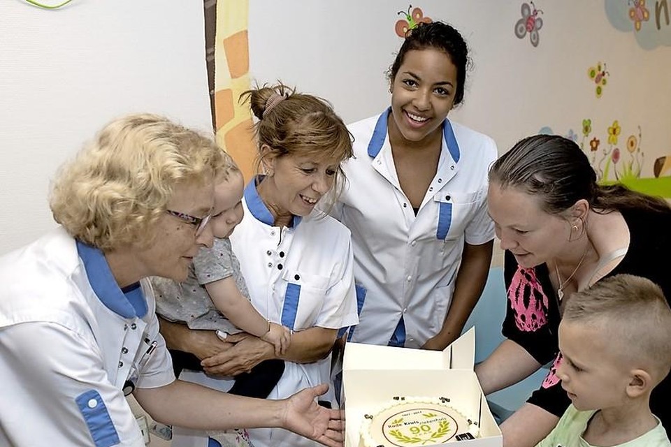 Verpleegsters Machteld de Kuiper, Els Kalkhoven (met Roos op de arm) en Sharon Sanders ontvangen de taart uit handen van het gezin.