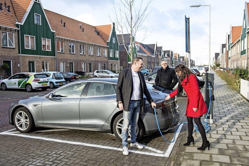Wethouder Nico van Baarsen keek in 2018 hoe bewoner Jan Paul Stegeman voor zijn Tesla de eerste elektrische laadpaal in Landsmeer aan de Zuiderzeelaan in gebruik neemt.