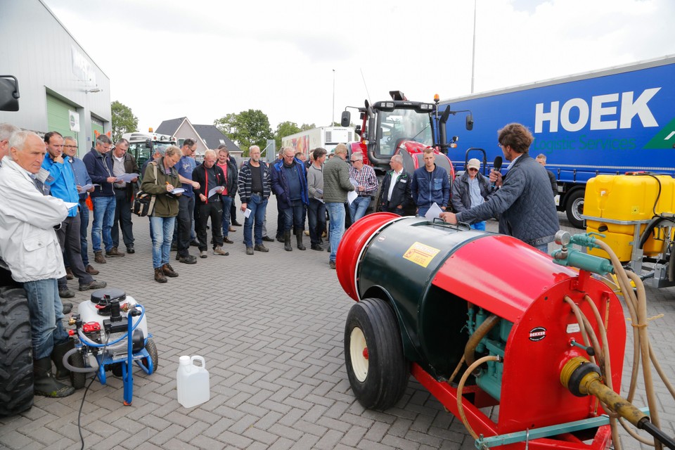 Fruittelers bijeen tijdens de Noord-Hollandse Fruitteeltdag luisteren aandachtig bij een demonstratie van een spuitmachine.