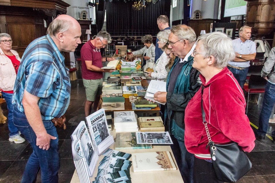 Miniboekenmarkt in de Bullekerk. Links van de tafel staan ’verkopers’ Harry van Nek en Hessel Kraaij van Historisch Zaandam.