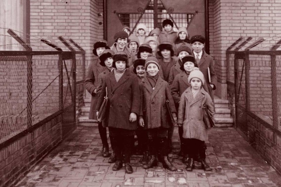 Een winterdag in 1929: Voor het naar school gaan poseren 19 kinderen uit het Joods Weeshuis aan de Roodenburgerstraatin Leiden voor de fotograaf.