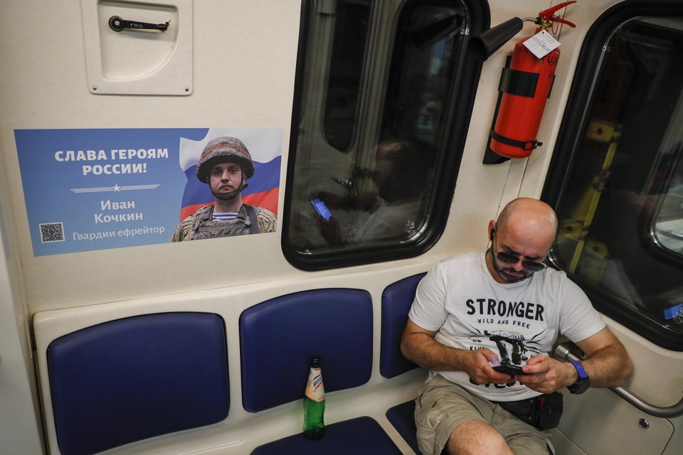 De metro in Moskou, aan de wand hangt een wervende poster met de tekst ’Glorie aan de helden van Rusland’.