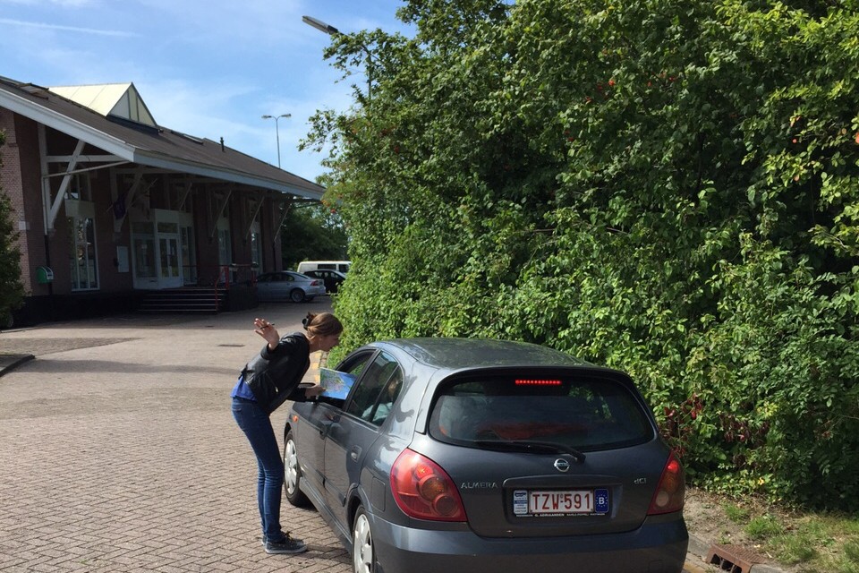 Een VVV-medewerkster vangt een bezoeker van Enkhuizen op bij het volle NS-parkeerterrein, om deze door te verwijzen naar de alternatieve plaatsen op bedrijventerrein Ketenwaal.