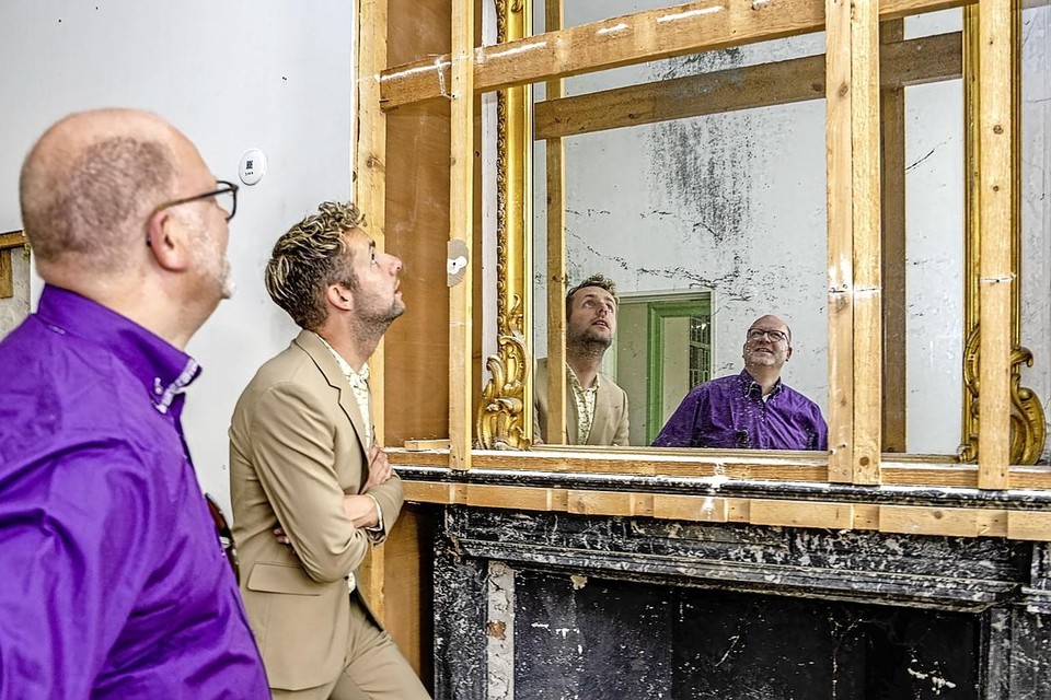Arthur Helling en Axel Boomgaars bewonderen de deels blootgelegde schouw met vergulde spiegel.