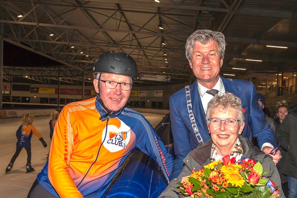 Piet Bloedjes (links) met zijn onderscheiding, opgespeld door burgemeester Toon Mans (rechts). Onder Bloedjes’ vrouw Tiny.