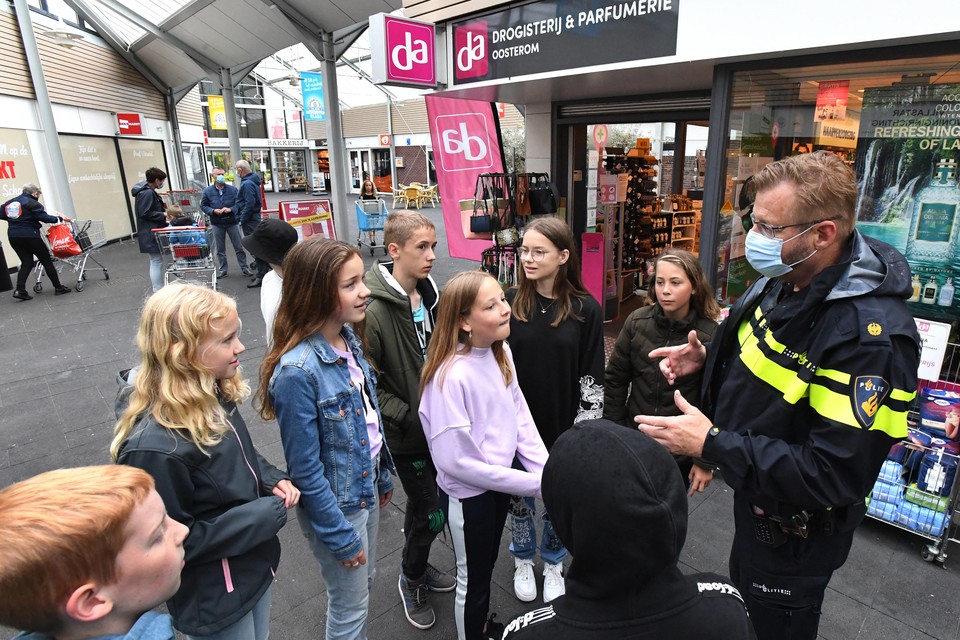 Een politieman legt in de zomer van 2021 aan kinderen uit wat wel en niet mag in winkelcentrum Schooten Plaza.