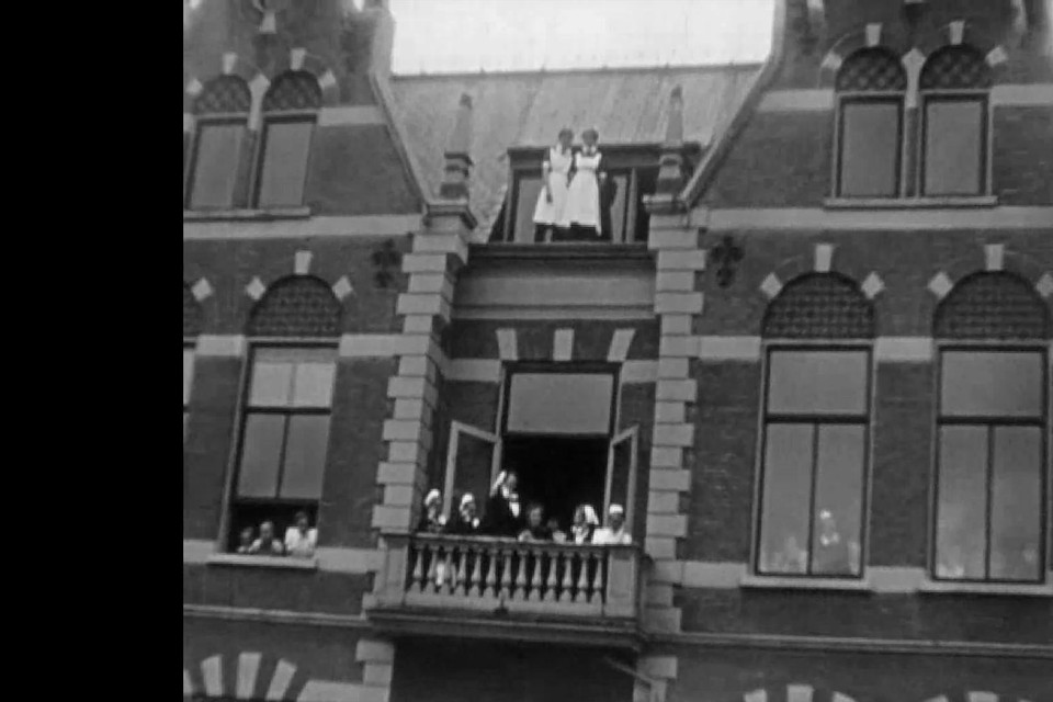 De verpleegkundigen wachten op het kleinste balkon op de optocht.
