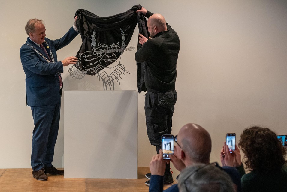 Kleinzoon Matthijs en burgemeester Voskuil onthullen het kunstwerk.