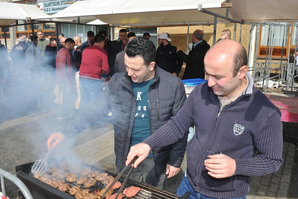 David Ciblak (l) en Bunyamin Acar zijn druk bezig met het vlees op de barbecue.