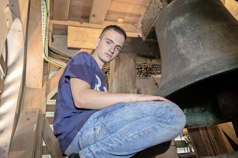 De 17-jarige Chardy van Riel uit Marken bij de bronzen klok in de toren van de Laurenskerk in Kolhorn. De jonge klokkenluisteraar reist door heel Nederland.