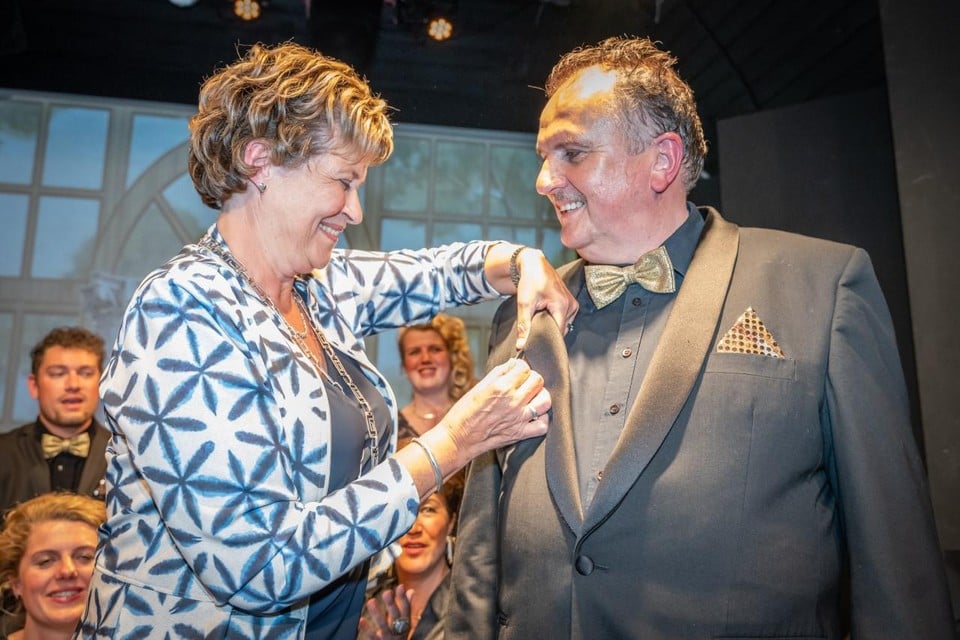Burgemeester Marjan van Kampen speldt de Koninklijke Onderscheiding op bij Paul Dekker.