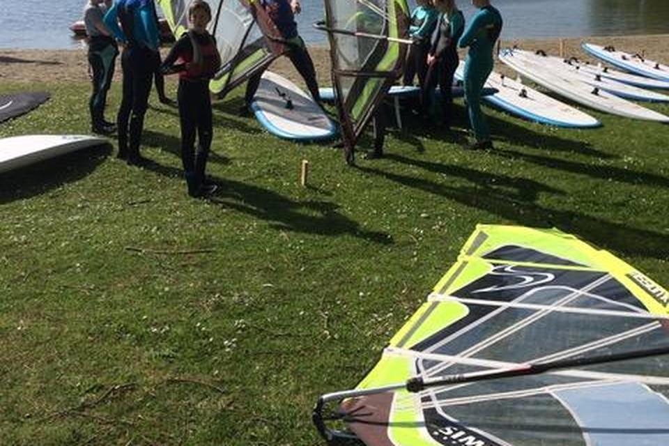 Instructie op de wal voor de jeugdige windsurfers.
