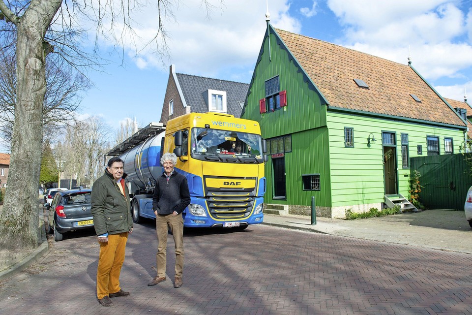 Jan Hartsuiker (l) en Hans Doornbos (bewoner van het groene huis) terwijl net weer een vrachtwagen voorbij komt.