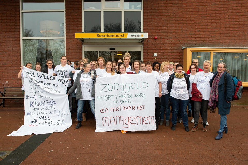 Actievoerende medewerksters van Evean Rosariumhorst in T-shirtjes en met spandoeken voor de ingang.