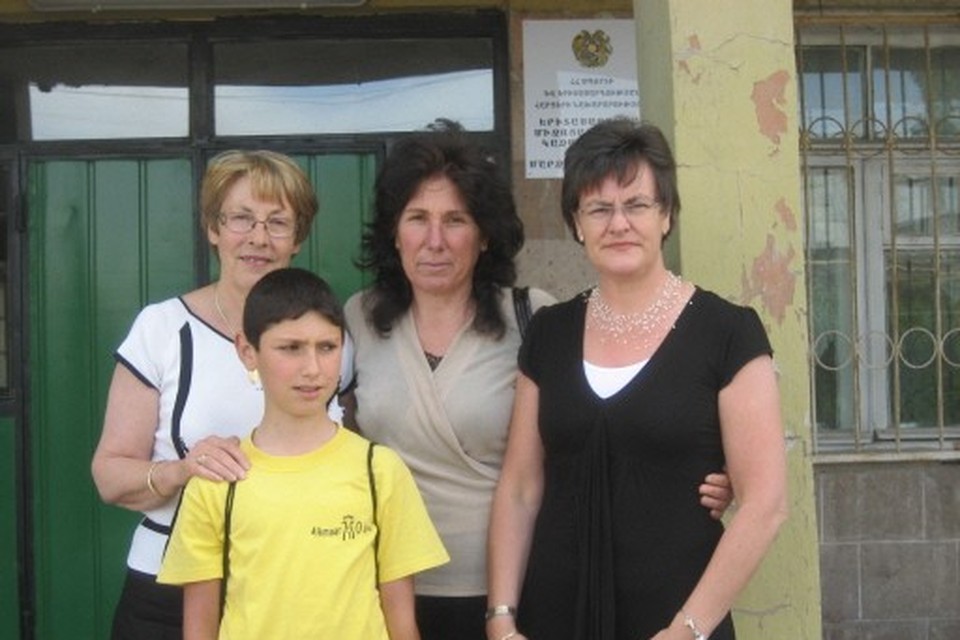 Marijke Langenberg (geheel links) en Carla Blom (geheel rechts) van de stichting Kinderhulp Armenië op bezoek bij een familie in Armenië.