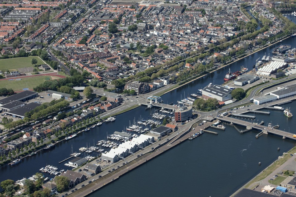 Binnen- en Buitenhaven van Den Helder vanuit de lucht gezien. In het midden het Havengebouw.
