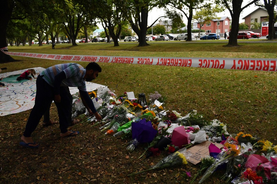 Iemand legt bloemen bij een van de getroffen moskeeën in Nieuw-Zeeland